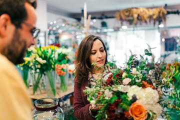 Wall Mural - Young woman buying a bouquet of flowers in a florist