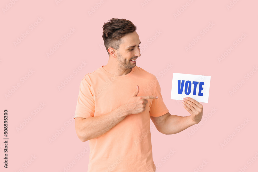 Young man holding paper with text VOTE on color background