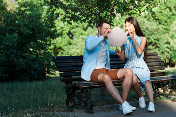 young couple sitting on a bench in the park