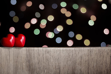 two red hearts on a fench with faded bokeh