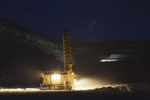 Quarry Drilling Machine Works Under The Light Of Artificial Illumination Inside A Huge Quarry In The Night Shift.