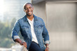 © elnariz - Portrait lifestyle head shot of an african american male in a blue jean jacket on a city urban rooftop, nice smile