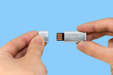 Gray USB Memory Stick On Hand With Blue Background
