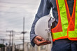 © Suriyo - Close up engineering holding white safety hard hat  standing out doors