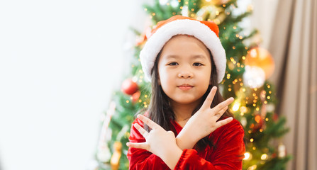 Wall Mural - Little asian girl smile and posing dance on christmas tree and white background.Child girl happy and dancing in Christmas celebration and Happy New year concept.