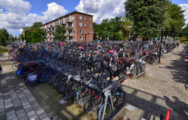 Amsterdam, Holland, August 2019. In the modern suburbs a large outdoor parking for bicycles. Thanks to two-level racks you can park a significant amount of two wheels.