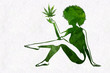 Woman's silhouette with afro hairstyle holding marijhuana leaf in her hand