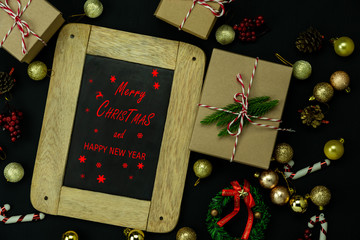 Wall Mural - Table top view of Merry Christmas decorations & Happy new year ornaments concept.Flat lay essential difference objects gift box & fir tree on modern black paper background at home studio office desk.