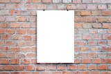 Fototapeta Tematy - Poster design presentation mockup. Blank paper poster hanging attached with clips across brick wall