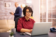 © DC Studio - Old woman in her 60s using a modern laptop in her cozy house