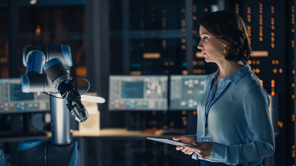Poster - Female Engineer with Tablet Computer Analyse How a Futuristic Robotic Arm Works and Moves a Metal Object. High Tech Research Laboratory with Modern Equipment.