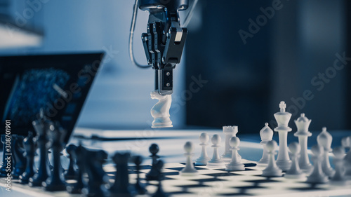 Close Up Vertical Shot of Artificial Intelligence Operating a Futuristic Robotic Arm in a Game of Chess. Robot Moves a Knight. High Tech Modern Research Laboratory.