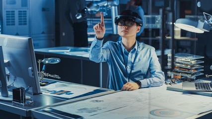 Fototapete - Professional Japanese Development Engineer is Working in a AR Headset, Making Gestures of Moving Virtual Graphics Pieces Around in the High Tech Research Laboratory with Modern Computer Equipment.