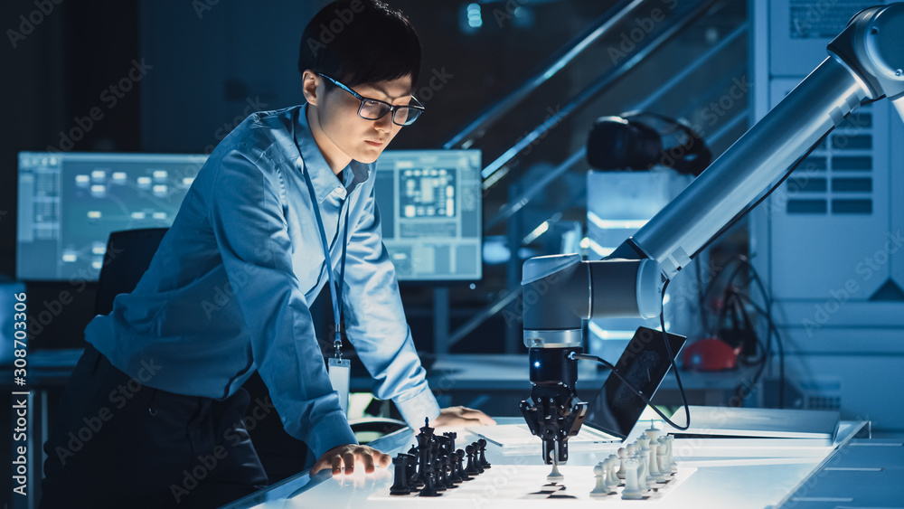 Professional Japanese Development Engineer is Testing an Artificial Intelligence Interface by Playing Chess with a Futuristic Robotic Arm. They are in a High Tech Modern Research Laboratory.