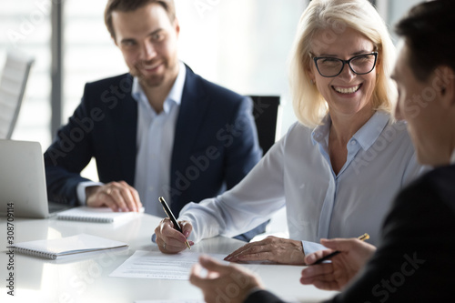 Fotomural Smiling mature businesswoman signing contract, agreement at meeting