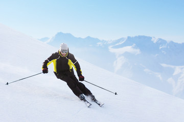 Wall Mural - Alpine skier on piste running downhill