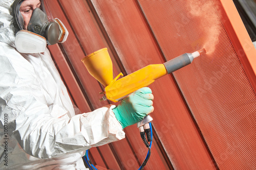 Fotografía polymer coating of metal detail with powder spraying gun