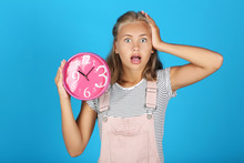 Young Girl Holding Round Clock On Blue Background