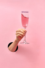 Rose Wine Glass In A Female's Hand From The Hole In The Wall.