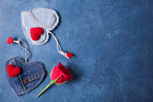 Blue Background For Valentine's Day Greetings With Red And Jeans Hearts And A Red Rose
