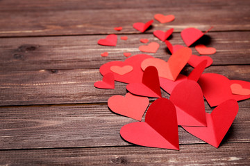 Wall Mural - Red paper hearts on brown wooden table