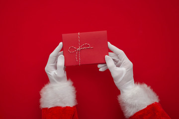 Wall Mural - Father Christmas holding a red blank card. Overhead view