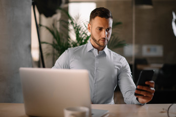 Businessman using phone in the office	