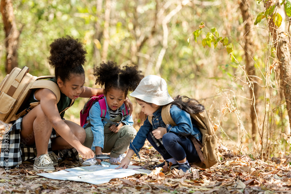 Group family children checking map for explore and find directions in the camping jungle nature and adventure. Tourism kids travel for destination and leisure trips for education and relax in nature  - obrazy, fototapety, plakaty 