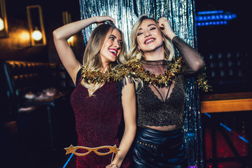 Girls celebrating new years eve at the nightclub. Group of female friends partying in pub