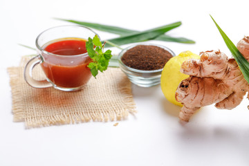 Black tea with lemon and ginger over white background 