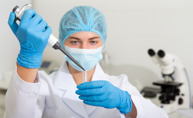 Poster - Female scientist dropping samples from big pipette for testing on modern lab equipment