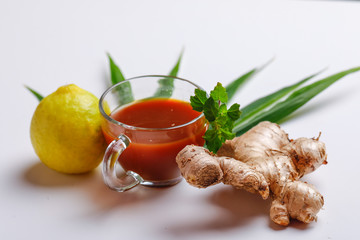 Black tea with lemon and ginger over white background 