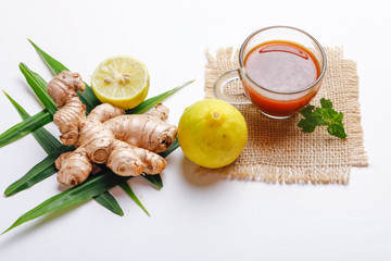 Black tea with lemon and ginger over white background 