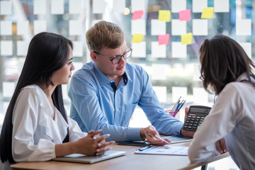 Business people gather to analyze marketing and investment information and using pen pointing to financial data chart at meeting.