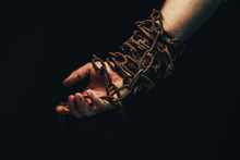 Human Hand Are Chained In Chains Isolated On Black Background.
