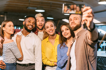 Casual business team taking selfie on smartphone