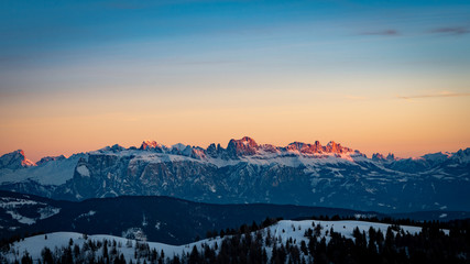 Wall Mural - Snowy rocky mountain with a beautiful pink sunset, space fort text