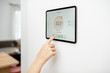 © rh2010 - Controlling temperature in the living room with a digital touch screen panel installed on the wall. Concept of heating control in a smart home, close-up on a screen