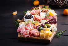 Antipasto Platter With Ham, Prosciutto, Salami, Cheese,  Crackers And Olives On A Wooden Background.  Christmas Table.