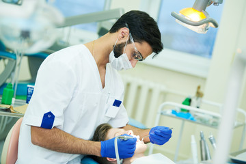 Wall Mural - male dentist at work with young patient