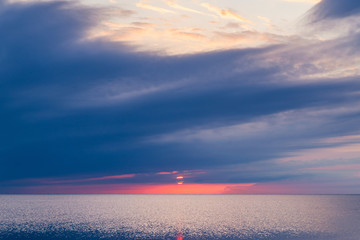 Wall Mural - Beautiful sunset in blue clouds on the seashore