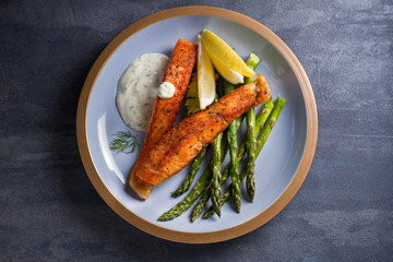 Delicious cooked salmon fish fillets with asparagus and lemon wedges