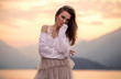 © kiuikson - Portrait of beautiful woman near the lake and mountains during the sunset