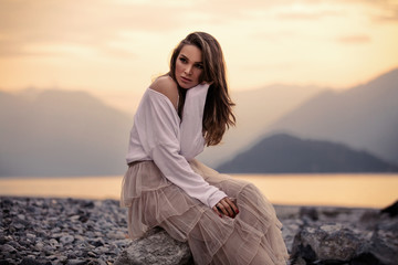 Fashionable female model in stylish outfit posing over mountain view