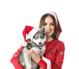 Sticker - Cute woman with funny husky puppy in Santa Claus hats on white background