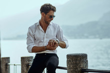 Stylish Man In White Shirt Checking The Time Over The Mountains Background