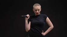 Beautiful Short Haired Blond Woman  With A Baseball Bat On Black Background