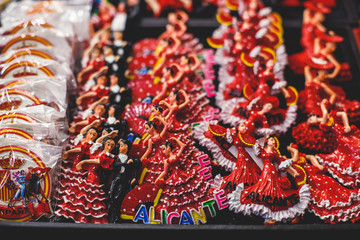 Wall Mural - View of traditional tourist souvenirs and gifts from Spain, Alicante, Valencia with toys, bull figures, flamenco dancer dolls, fridge magnets with and key ring keychain, in local vendor souvenir shop