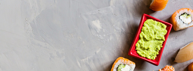 Top view on traditional japanese empty with sushi, ginger, soy sauce, wasabi on concrete gray background, mock up. Online food delivery concept