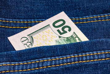 Wall Mural - American fifty dollar banknote back side in pocket of blue jeans